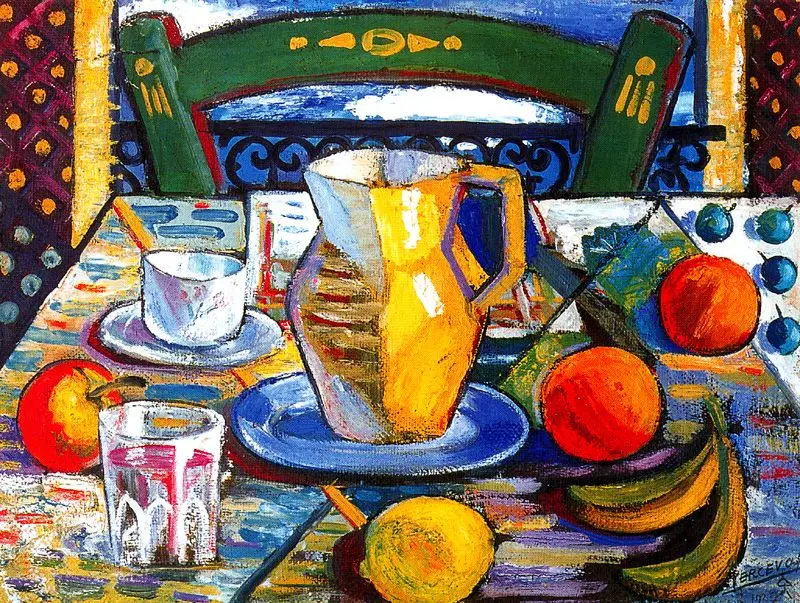 Naturaleza muerta del pintor Jesús de Perceval, con una escena colorida de mesa donde destacan una jarra amarilla sobre un plato azul, rodeada de frutas como naranjas, plátanos, un limón, una manzana y un vaso de agua. Al fondo, una silla verde y motivos decorativos transmiten el calor y la vitalidad del Mediterráneo.