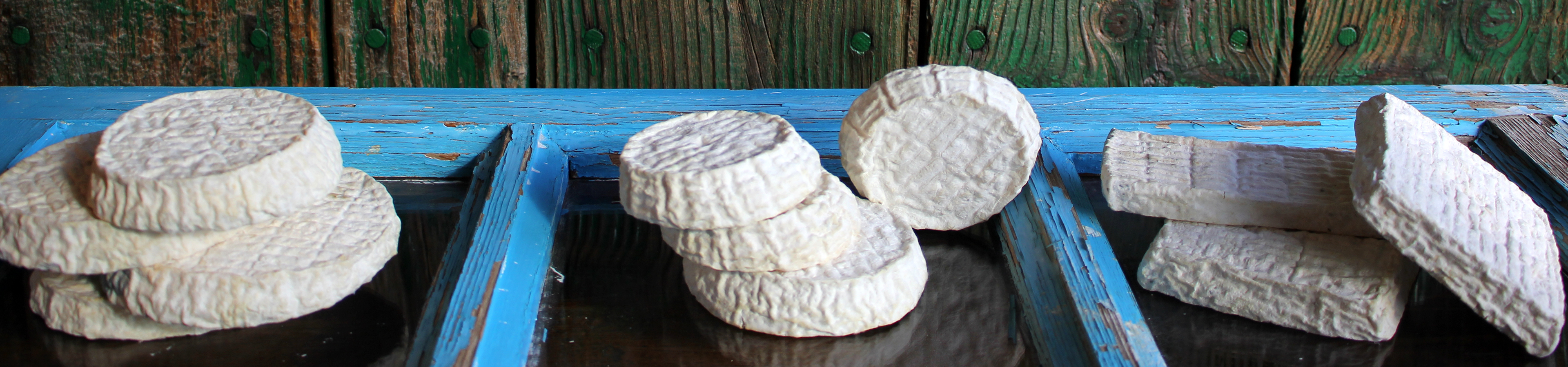 Quesos artesanos de la quesería La Indaliana expuestos sobre una antigua ventana de cortijo, reflejando la tradición y el trabajo artesanal.